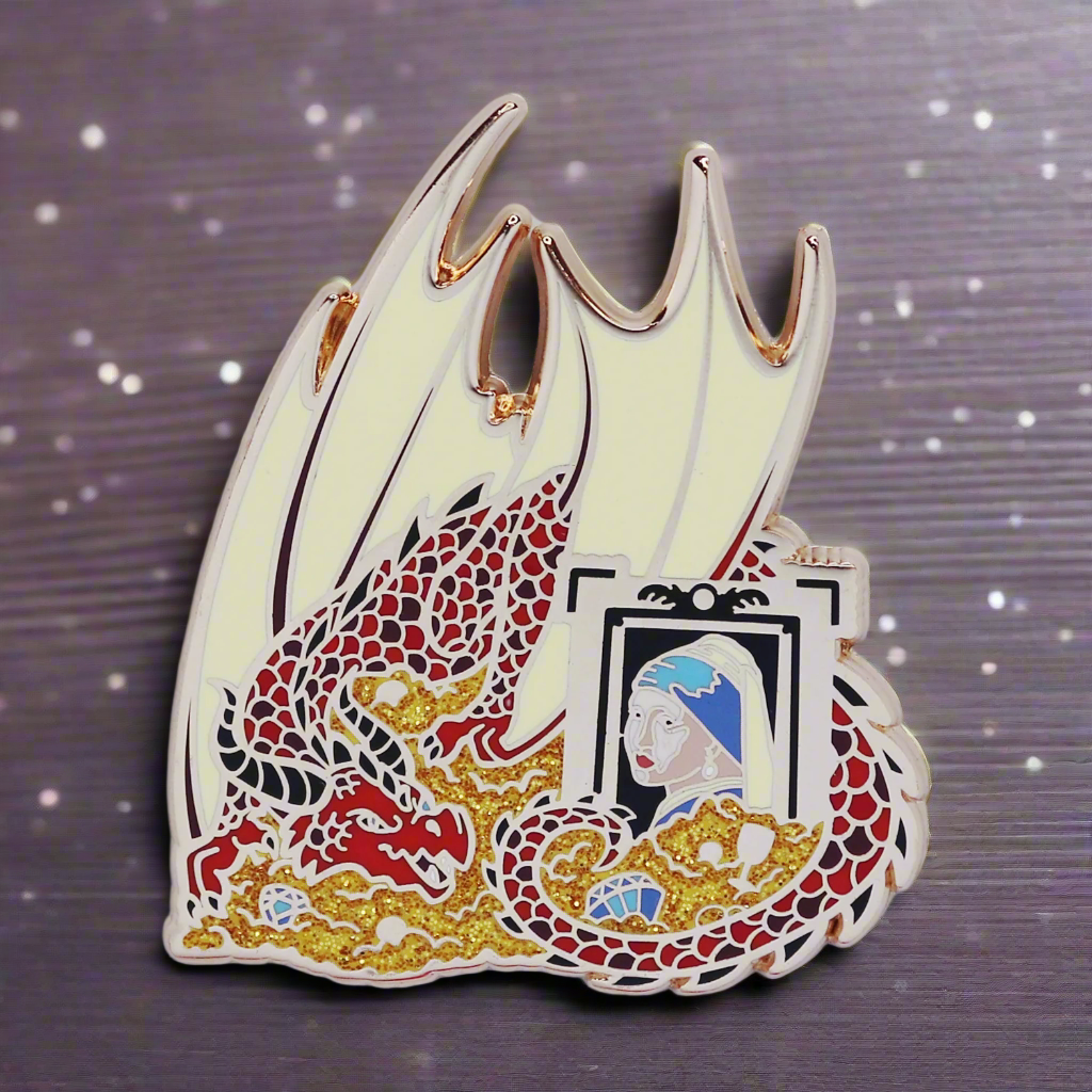An enamel pin featuring a red and gold dragon with a hoard of treasure and a painting of a girl with a pearl in the hoard.