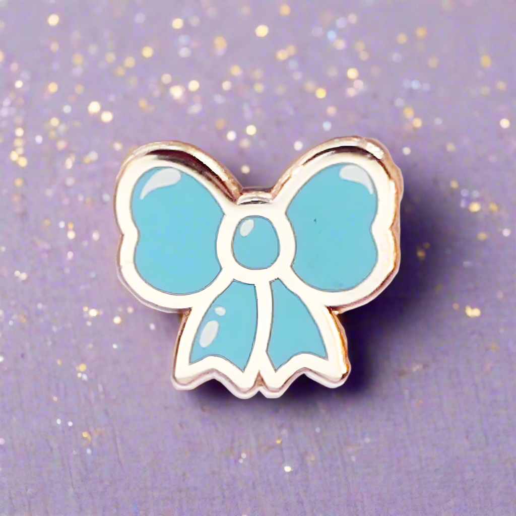 Blue bow-shaped pin on a glittery purple background