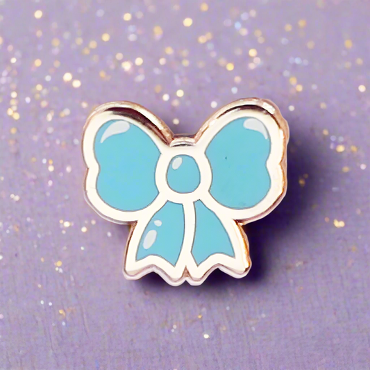 Blue bow-shaped pin on a glittery purple background