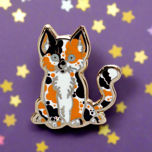 A gold metal hard enamel pin shaped like a kitten with an orange and black color scheme.