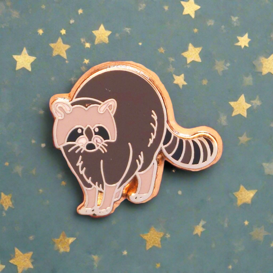 Raccoon-shaped pin on a pastel background