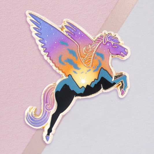 A gold metal enamel pin featuring a mythological creature, Pegasus, with a gradient sky background and clear pearl fill.